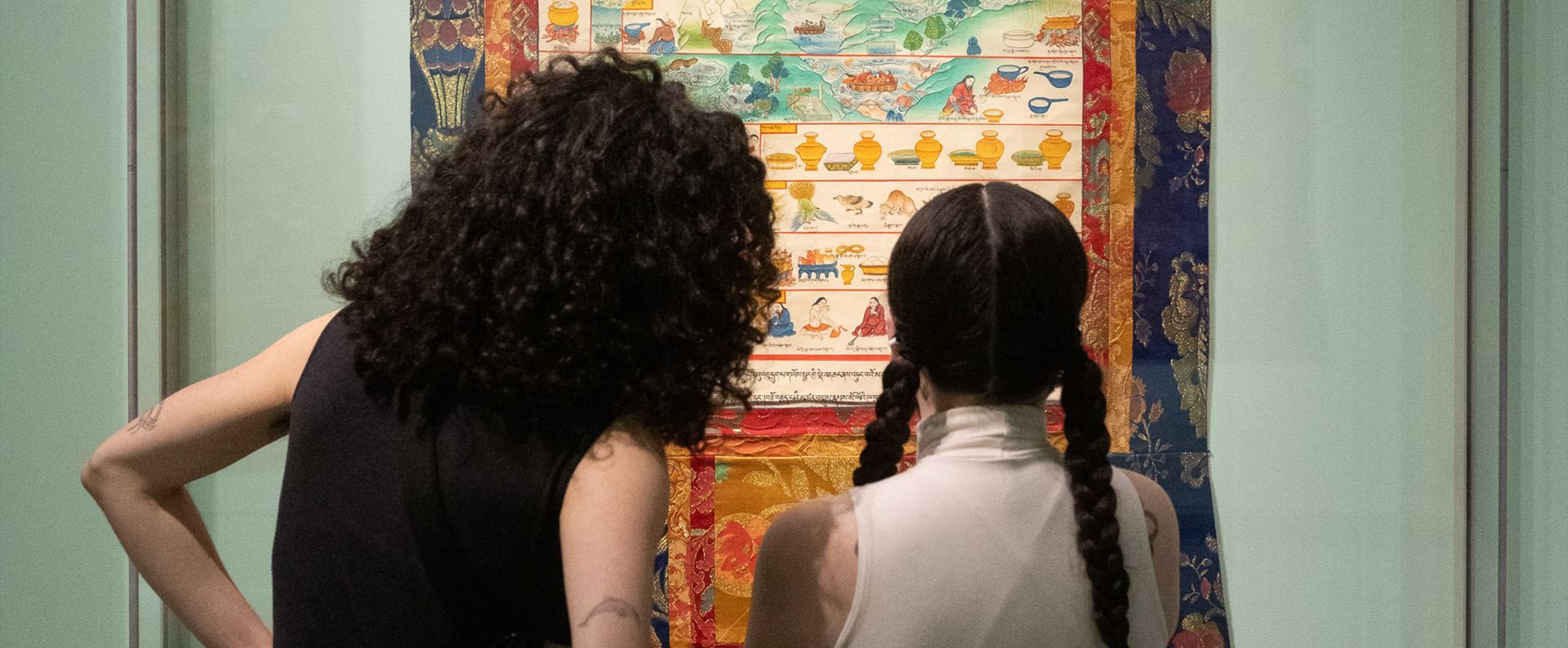 Two people looking at artwork that’s hanging on a wall